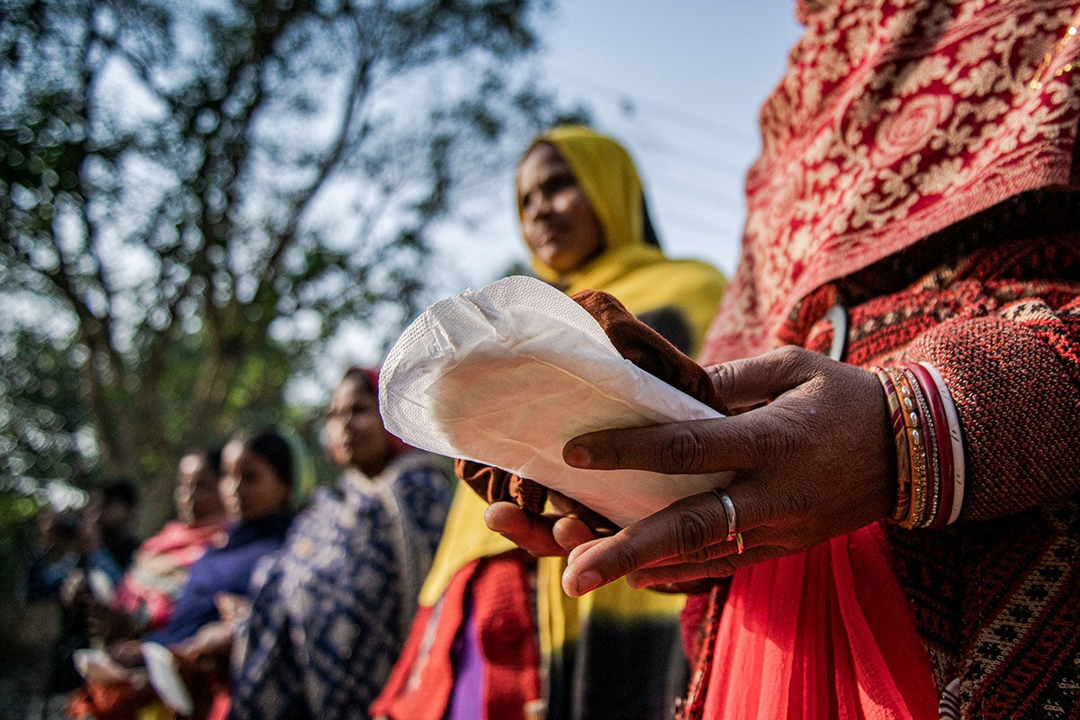En el estado de Sitamarhi, Bihar, la India, en 2022, varias mujeres sujetan compresas durante una campaña informativa como parte del programa de gestión de la higiene menstrual organizado por UNICEF