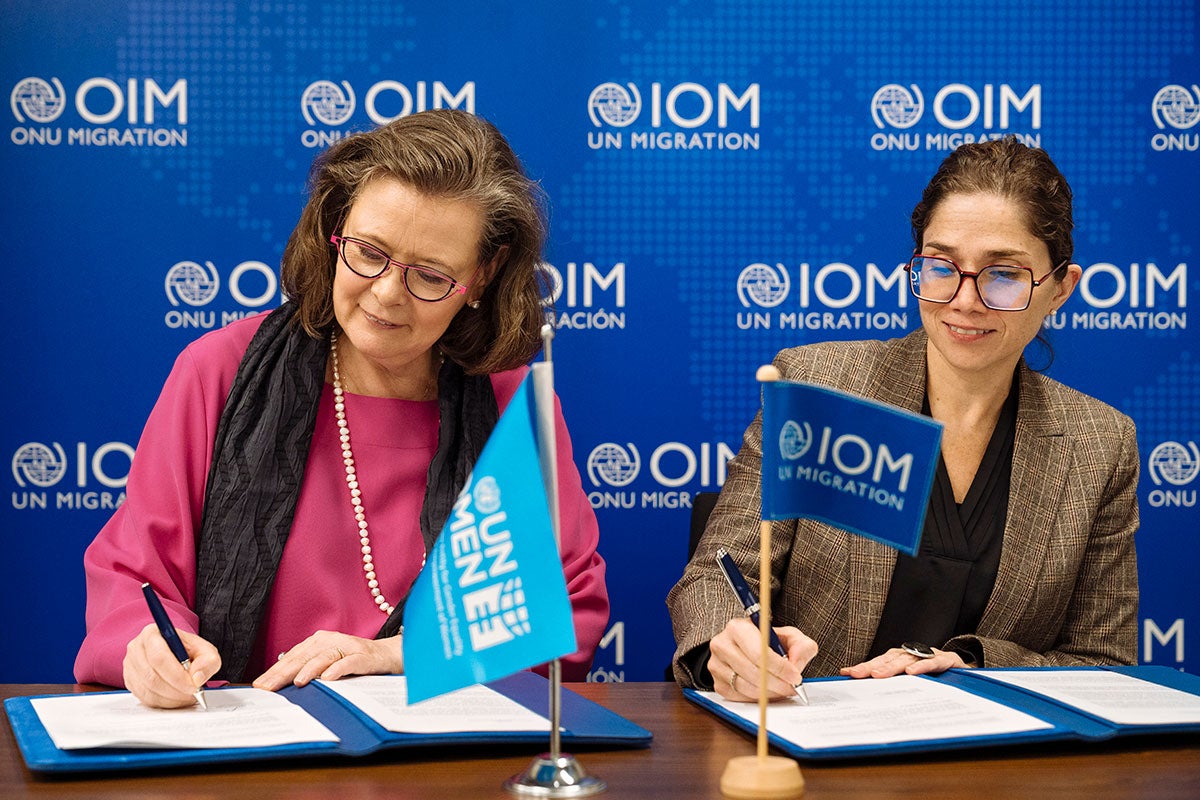 UN Women Deputy Executive Director Kirsi Madi (left) signs a new partnership with Catalina Devandas, IOM Representative of the Director General Office of Partnerships, Advocacy, and Communication.