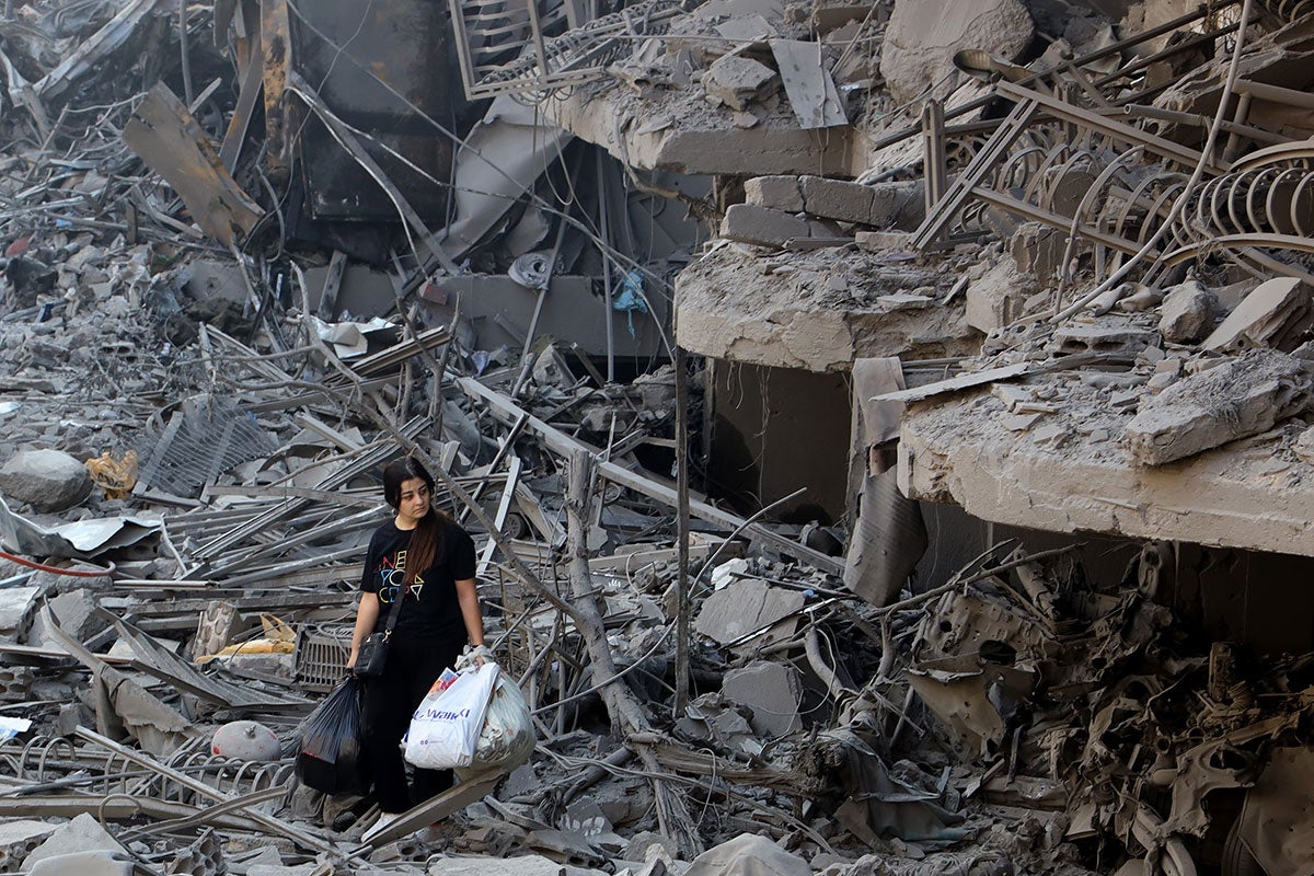 On 29 September 2024 a woman in Beirut, Lebanon walks among the debris of buildings destroyed by airstrikes.