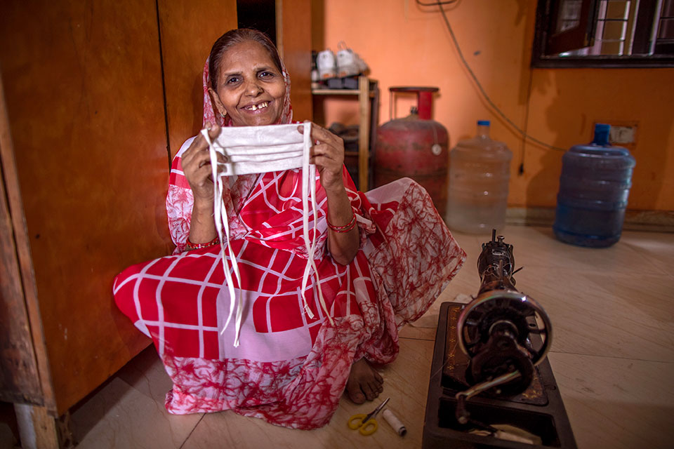 Laxmi Devi, 55, shows a mask she has made. She is using the sewing machine that she bought with a loan received through SEWA to make and sell masks in New Ashok Nagar neighbourhood of New Delhi. Her mindset about women and work has changed. When she was younger, women didn’t work, but she says now are different. “Girls should go out and work now. Boys and girls are equal,” she says. Photo: UN Women/ Prashanth VIshwanathan