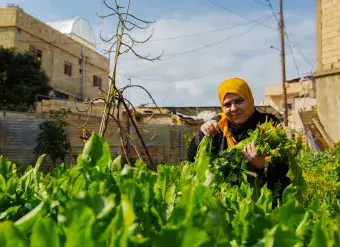 Aida Ghadban with her homegrown vegetables. Photo: UN Women/Lauren Rooney