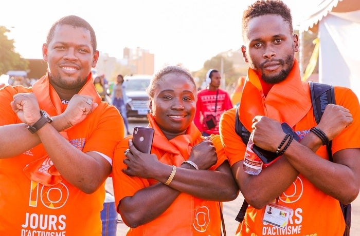 Three young activists wear orange during the sixteen days of activism against gender-based violence. 